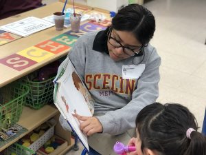 student reading to preschooler