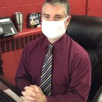 Interim principal David Dellacca sitting at his desk wearing his mask